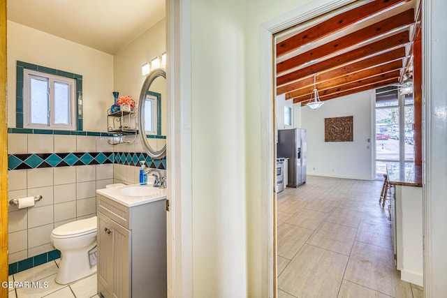 8024 Tonto Pl, El Paso, TX 79904 - bathroom with tile patterned floors, beamed ceiling, toilet, vanity, and tile walls