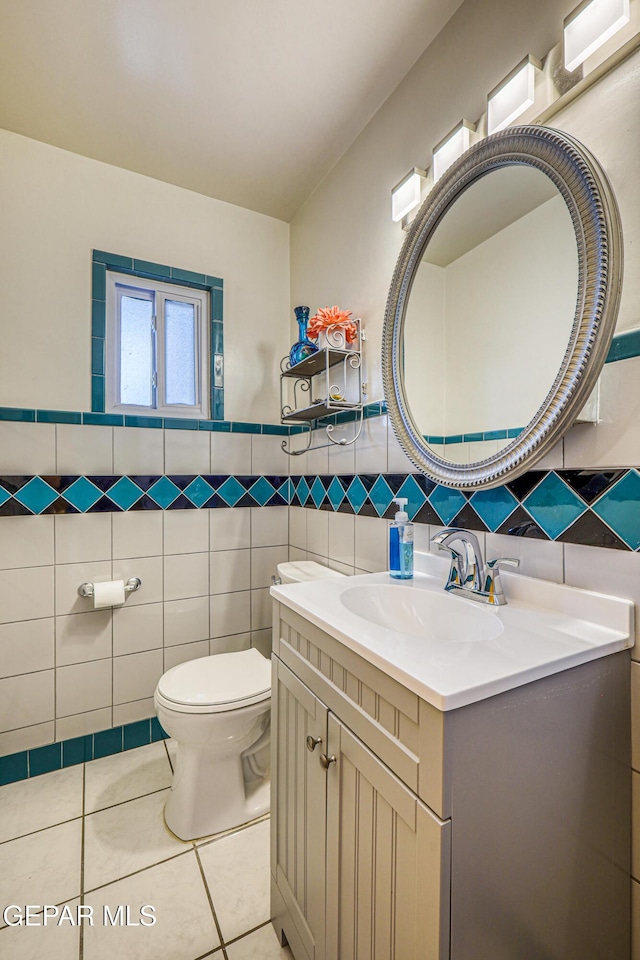8024 Tonto Pl, El Paso, TX 79904 - bathroom featuring tile walls, toilet, tile patterned floors, vanity, and a wainscoted wall