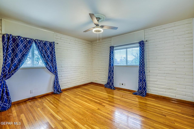 8024 Tonto Pl, El Paso, TX 79904 - unfurnished room featuring light wood-style flooring, a ceiling fan, plenty of natural light, baseboards, and brick wall