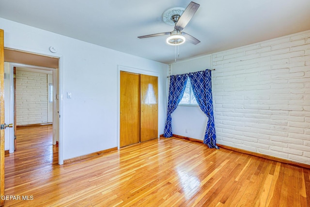 8024 Tonto Pl, El Paso, TX 79904 - unfurnished bedroom with brick wall, baseboards, light wood finished floors, a closet, and ceiling fan