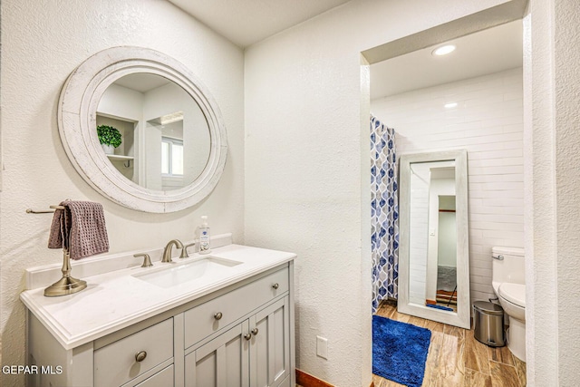 8024 Tonto Pl, El Paso, TX 79904 - bathroom featuring toilet, vanity, wood finished floors, curtained shower, and a textured wall