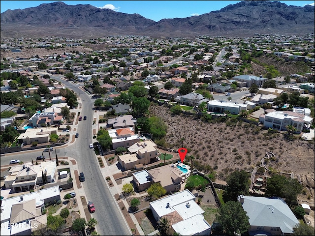 aerial overview of property's location with a mountainous background and nearby suburban area
