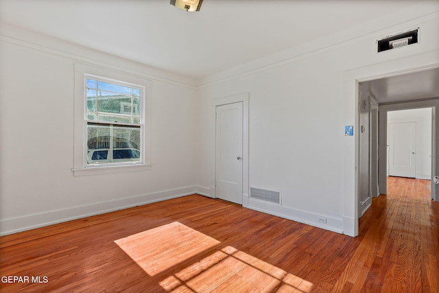 empty room featuring wood finished floors and baseboards