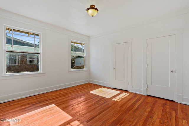 spare room featuring wood finished floors and baseboards