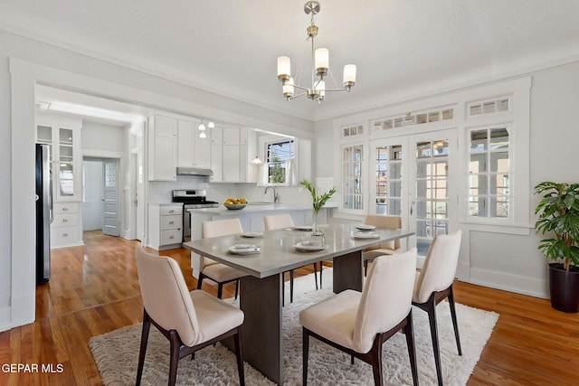 dining space featuring a chandelier, wood finished floors, and baseboards