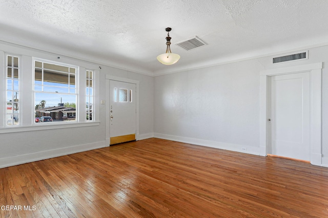 entryway featuring wood-type flooring, baseboards, and a textured ceiling