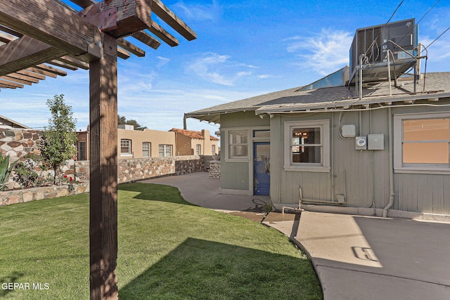 view of exterior entry with a pergola, cooling unit, a patio area, and a shingled roof