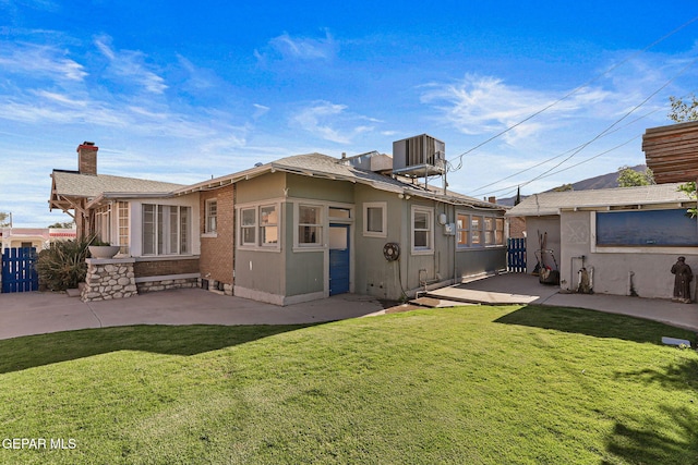 back of house featuring a patio area, a chimney, and central AC
