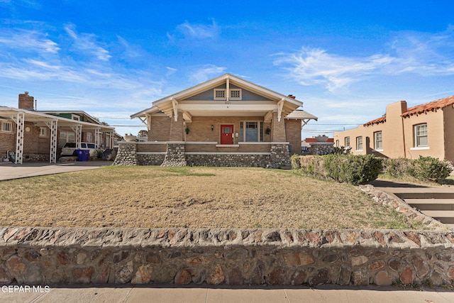 view of front facade with brick siding, a porch, and a front yard