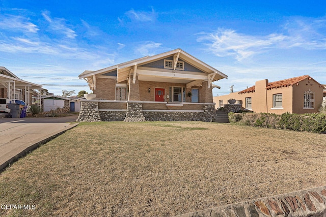 view of front of house with brick siding, covered porch, and a front lawn