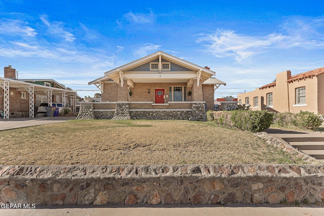 view of front of property with covered porch, brick siding, and a front yard