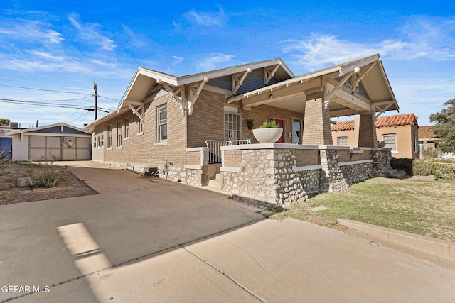view of property exterior featuring brick siding, concrete driveway, and a lawn