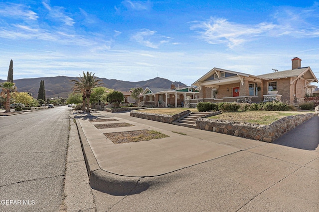 view of front of property with a chimney, a mountain view, and brick siding