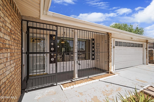 view of exterior entry with driveway and an attached garage