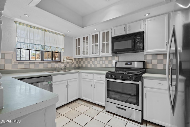 kitchen with stainless steel appliances, light countertops, white cabinetry, a sink, and recessed lighting