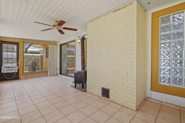 unfurnished sunroom with a wood stove and cooling unit