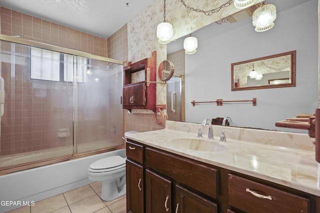 full bath with toilet, tile patterned flooring, vanity, and bath / shower combo with glass door