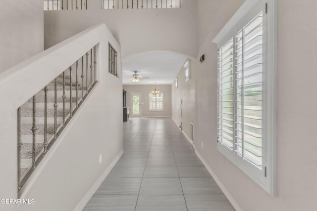3096 Java Chip Pl, El Paso, TX 79938 - corridor with baseboards, tile patterned floors, arched walkways, a chandelier, and a towering ceiling