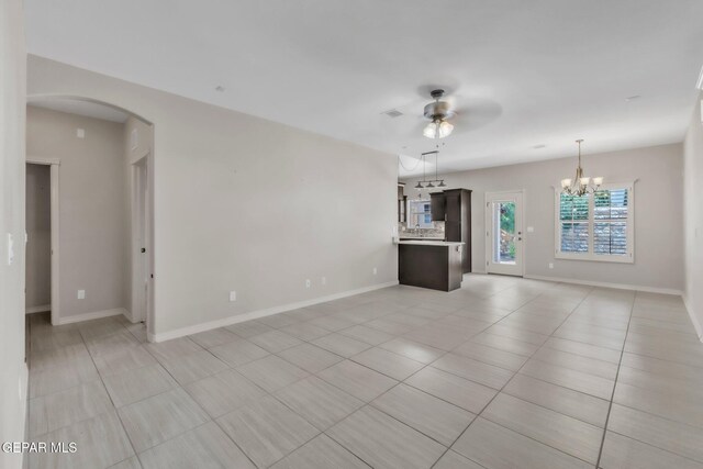 3096 Java Chip Pl, El Paso, TX 79938 - unfurnished living room featuring arched walkways, a ceiling fan, light tile patterned floors, and baseboards