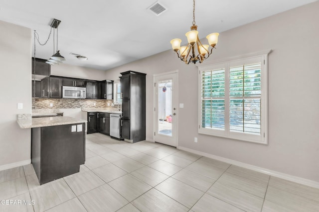 3096 Java Chip Pl, El Paso, TX 79938 - kitchen featuring white microwave, stainless steel dishwasher, backsplash, a chandelier, and hanging light fixtures