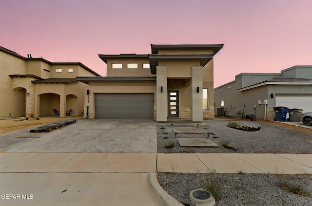 14740 Jack White Ave, El Paso, TX 79938 - view of front of house with stucco siding, concrete driveway, stone siding, and central AC unit