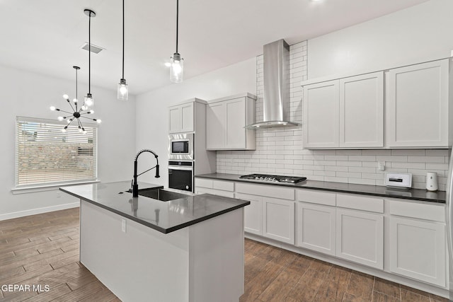14740 Jack White Ave, El Paso, TX 79938 - kitchen featuring wall chimney range hood, appliances with stainless steel finishes, a sink, and dark countertops