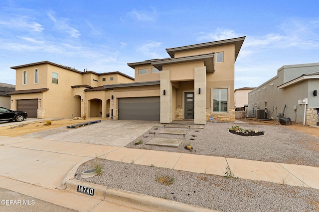 14740 Jack White Ave, El Paso, TX 79938 - view of front of property featuring stucco siding, driveway, stone siding, central air condition unit, and a garage