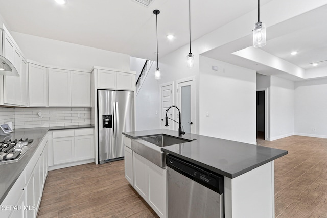 14740 Jack White Ave, El Paso, TX 79938 - kitchen featuring appliances with stainless steel finishes, a sink, light wood-type flooring, tasteful backsplash, and open floor plan