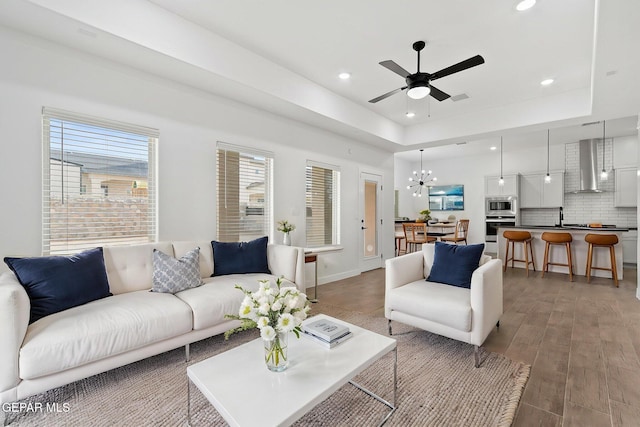 14740 Jack White Ave, El Paso, TX 79938 - living area featuring a ceiling fan, recessed lighting, light wood finished floors, a chandelier, and a raised ceiling