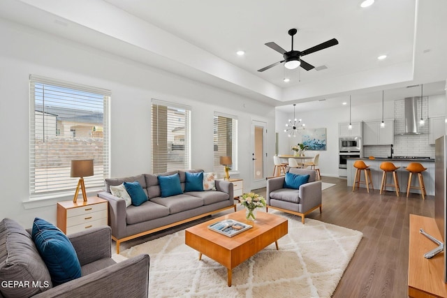 14740 Jack White Ave, El Paso, TX 79938 - living area with light wood-style floors, ceiling fan, recessed lighting, a chandelier, and a tray ceiling