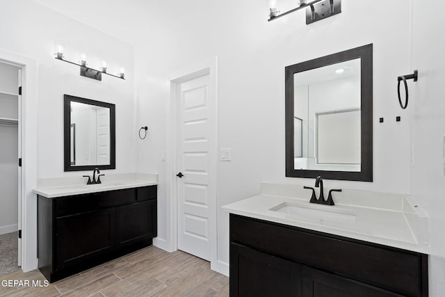 14740 Jack White Ave, El Paso, TX 79938 - bathroom with wood finished floors, two vanities, and baseboards