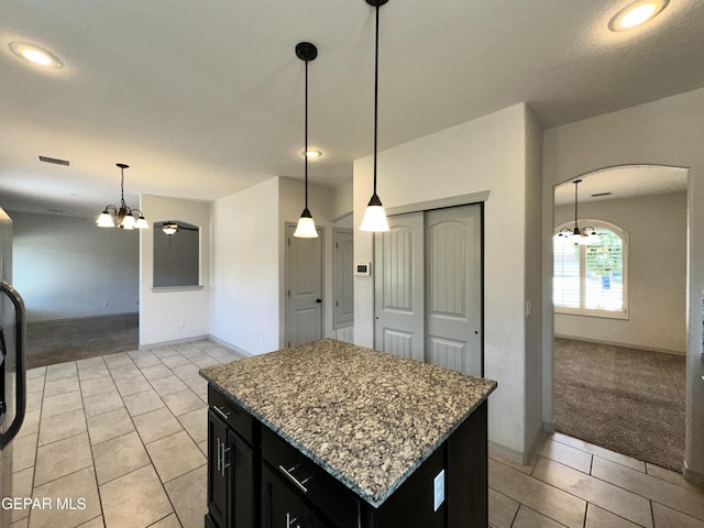 13192 Lost Willow, El Paso, TX 79938 - kitchen with a chandelier, arched walkways, dark cabinets, light carpet, and light tile patterned floors
