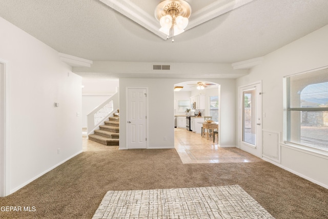 foyer entrance with ceiling fan, carpet flooring, baseboards, and stairway