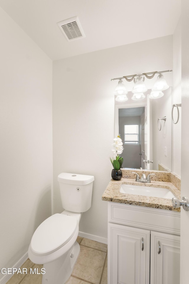 bathroom with toilet, baseboards, vanity, and tile patterned flooring