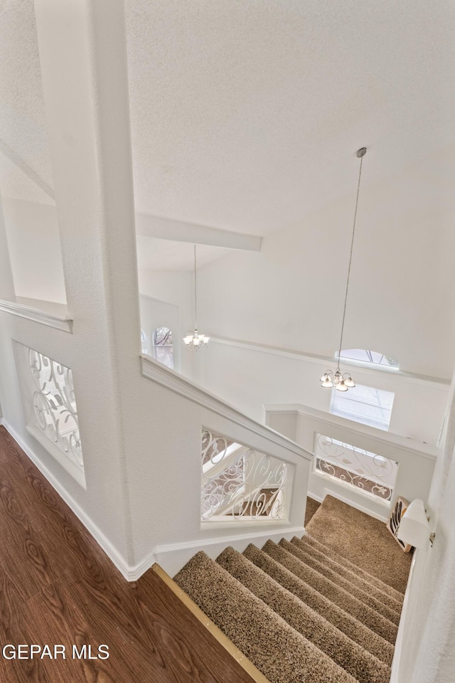 staircase with a chandelier and baseboards