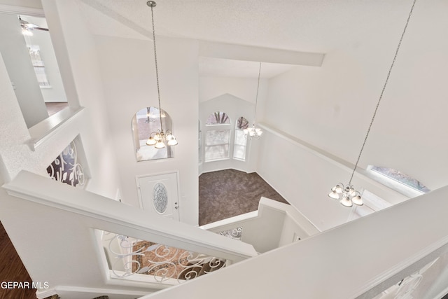 staircase featuring a chandelier and lofted ceiling