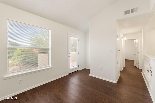 spare room featuring dark wood finished floors and baseboards