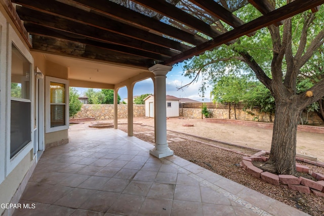 view of patio / terrace with a storage unit, an outdoor structure, and a fenced backyard