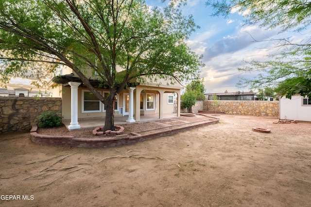 back of house featuring fence, covered porch, and stucco siding