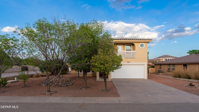 view of front facade featuring a garage, concrete driveway, stucco siding, a tiled roof, and central AC unit