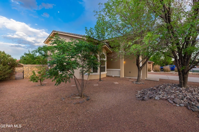 view of front of property featuring stucco siding and fence
