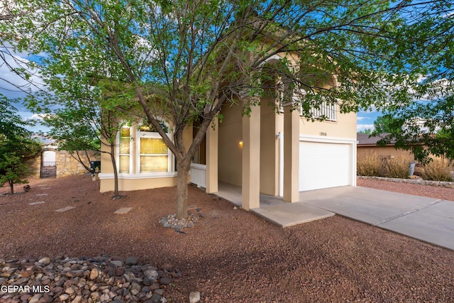 view of front of property with stucco siding, concrete driveway, and an attached garage