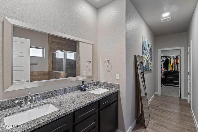 14840 Pebble Hills Blvd, El Paso, TX 79938 - full bath with a textured wall, a walk in closet, a tile shower, double vanity, and baseboards