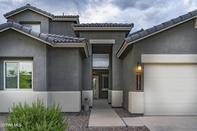 13673 Samlesbury Ave, Horizon City, TX 79928 - view of front facade featuring a garage, stucco siding, and a tile roof