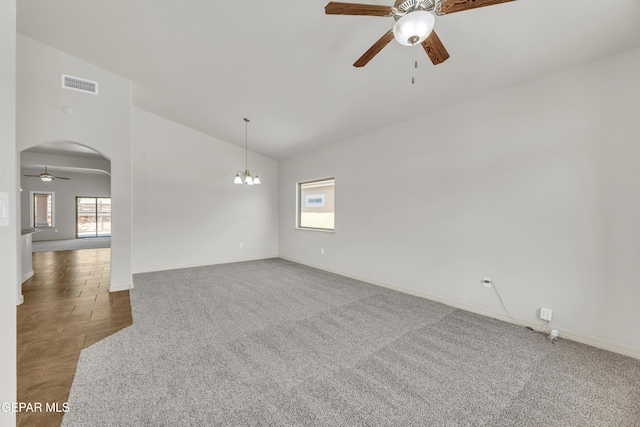empty room with ceiling fan, baseboards, arched walkways, carpet, and high vaulted ceiling