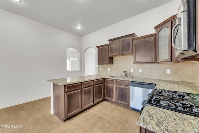 kitchen featuring stainless steel appliances, a sink, a peninsula, decorative backsplash, and recessed lighting