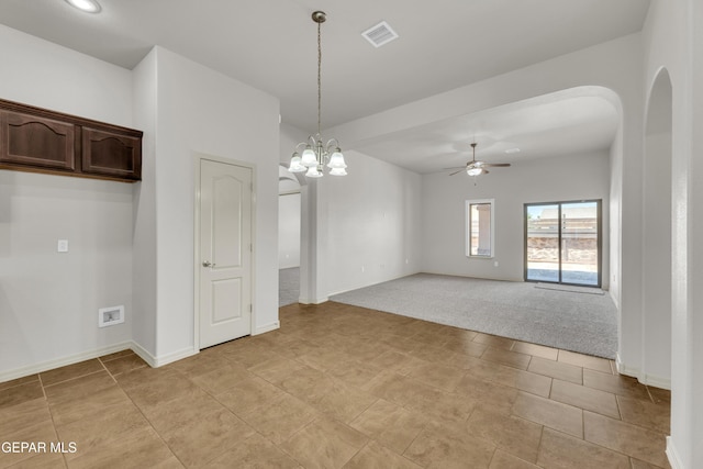 empty room with ceiling fan, arched walkways, light carpet, baseboards, and a chandelier