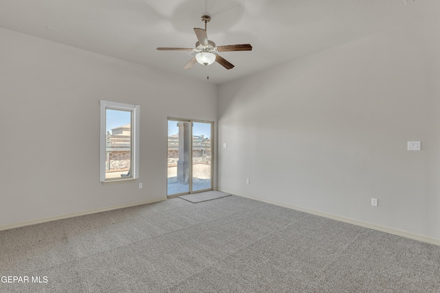 unfurnished room with carpet floors, a ceiling fan, and baseboards