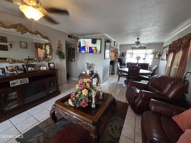 tiled living area with a ceiling fan and a textured ceiling