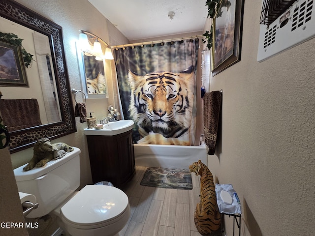 bathroom featuring a textured wall, wood finished floors, toilet, vanity, and shower / bathtub combination with curtain